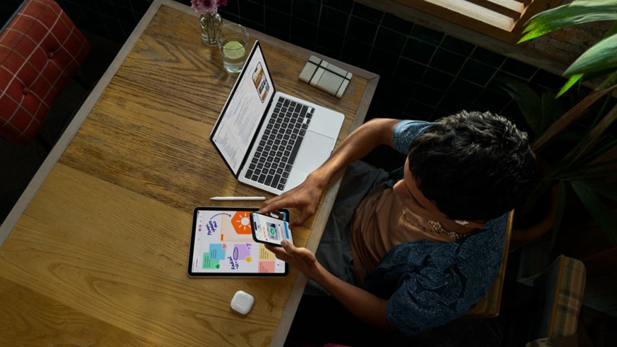Muž sedící u stolu a sledující novinky Apple prezentované na konferenci WWDC 2026