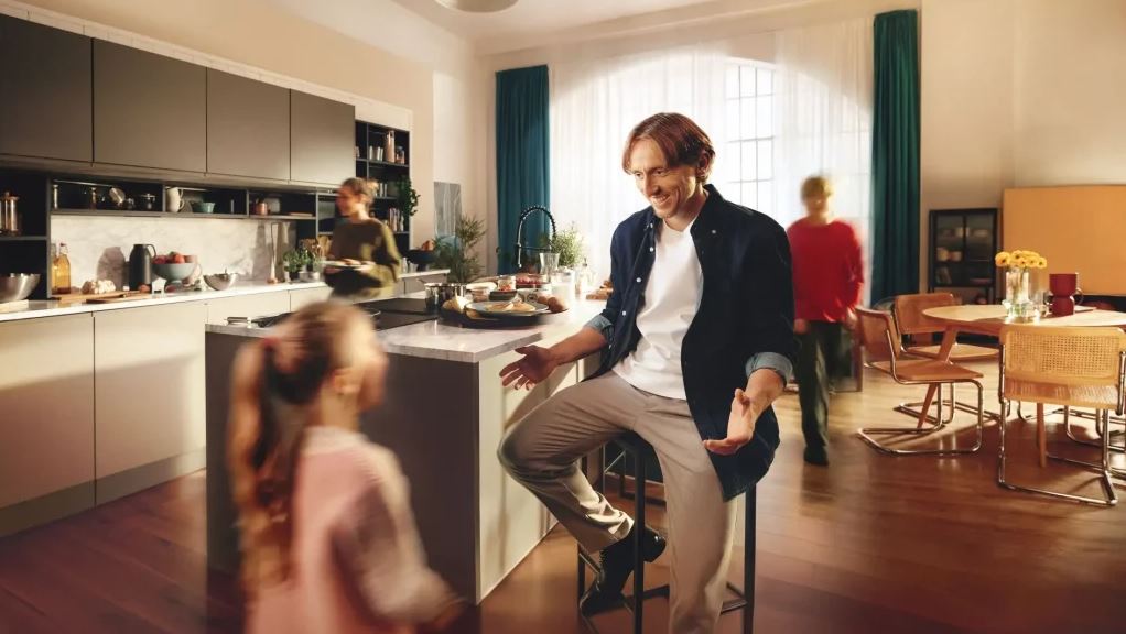 Fotbalová legenda Luka Modrić a značka Gorenje spojují své síly Luka Modric sedi v kuchyni na zidli a s otevrenou naruci vita pribihajici divku. V pozadi dvě ženy