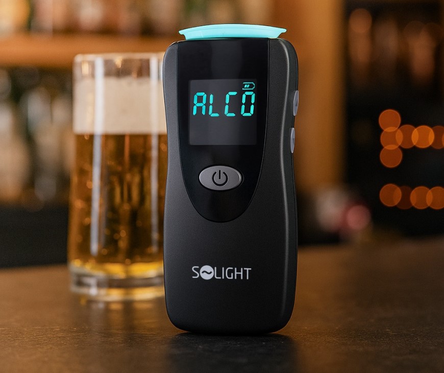 Alkohol tester SoLight a v pozadí se nachází pivo