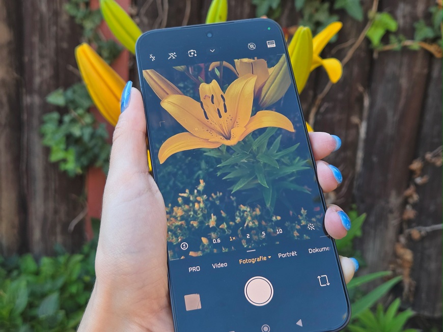 Recenze: Xiaomi 17T Pro – Xiaomi 17T Pro s otevřeným fotoaparátem ostří na květy lilie.
