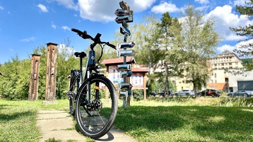 Recenze: Elektrokolo GoGEN Aspen MX 720 se postará o to, aby vaše cyklochoutky nic nebrzdilo Elektrokolo GoGEN Aspen MX 720 v šedo-černém provedení, odstavené před rozcestníky