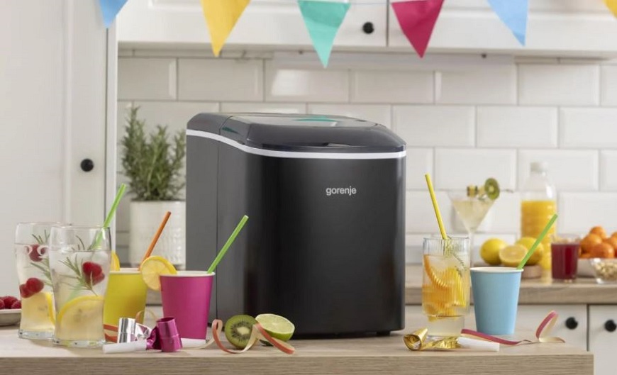 Nejlepší pomocníci na léto? Vychytávky Gorenje pro prázdninovou pohodu výrobník ledu gorenje stojí na kuchynské lince a vedle jsou připravene nápoje s brčkem