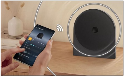 Bezdrátový reproduktor Samsung Music Studio: Stylový design a výjimečný zvuk clovek drzi telefon v ruce a ma v nam pustenou aplikaci k prehravani hudby pres reproduktor