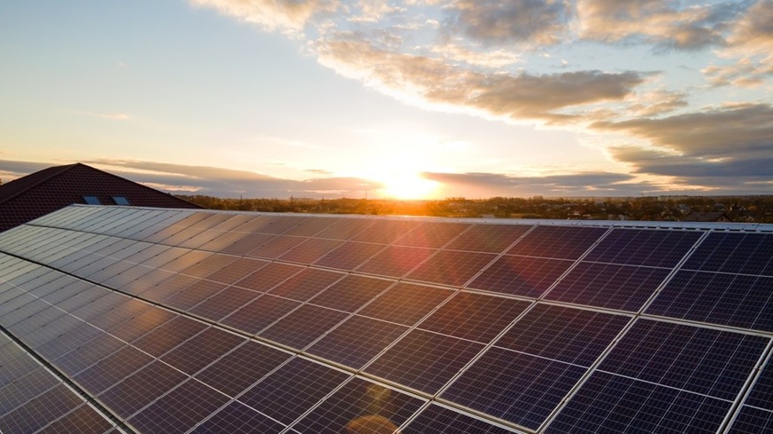 Jak na fotovoltaiku v roce 2026: Získejte solární elektrárnu bez úroků a počátečních úspor! Řada fotovoltaických panelů zachycená při západu Slunce.