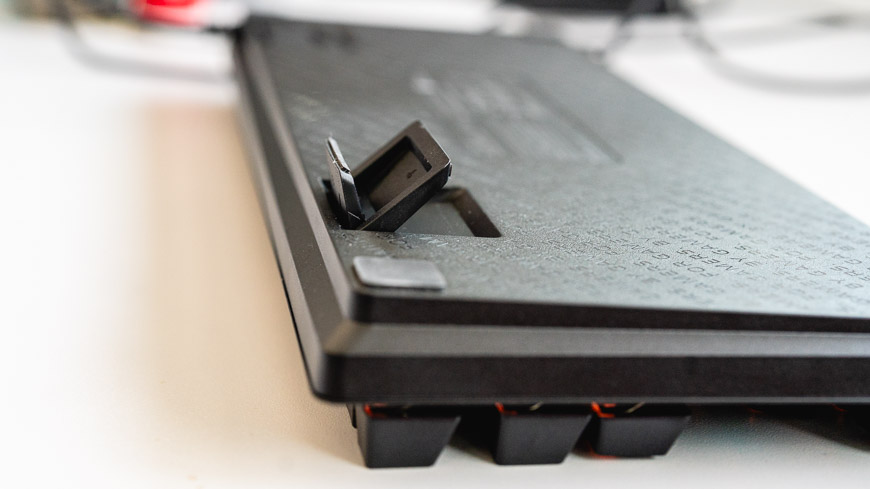 Herní klávesnice Razer Huntsman Tenkeyless V3 8KHz leží otočená vzhůru nohama, nastavitelné dvojité pacičky jsou napůl vytažené