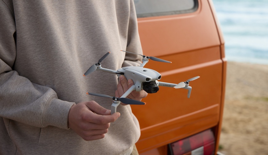 TEST: Jaký DJI dron vybrat? Srovnání modelů pro začátečníky, cestování i profesionální tvorbu muž drží dron dji lito x1 před dodávkou