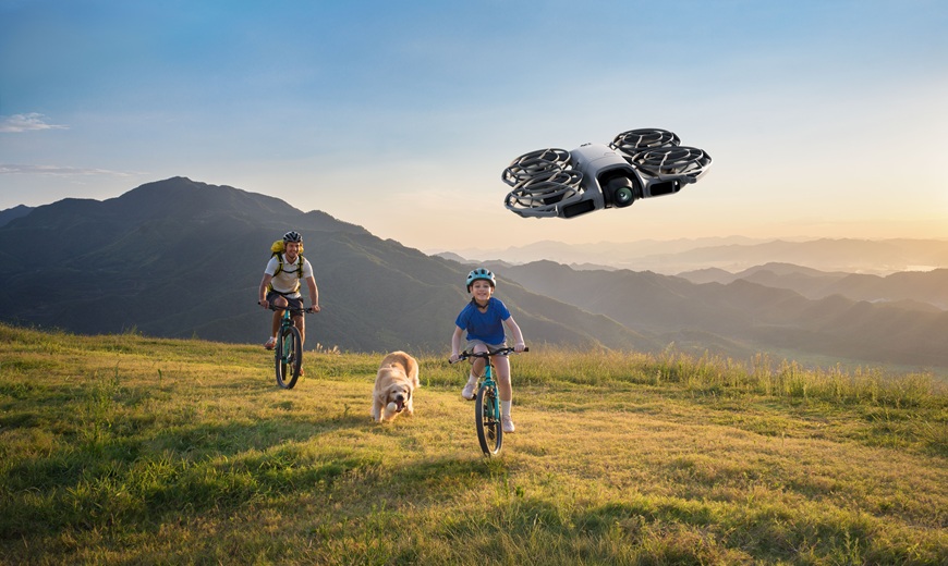 TEST: Jaký DJI dron vybrat? Srovnání modelů pro začátečníky, cestování i profesionální tvorbu muž a dítě na kole se psem jedou na louce natáčí s dronem dji neo 2