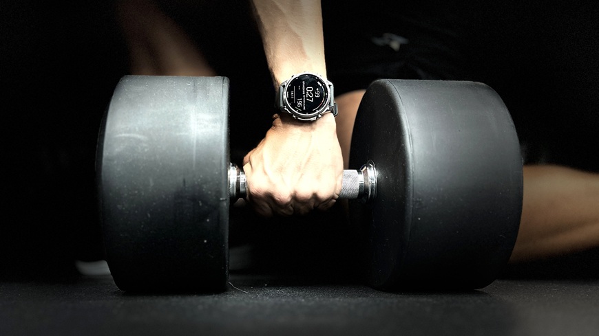 Chytré hodinky Garmin fēnix® 9 Pro na zápěstí muže zvedajícího činku
