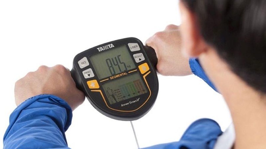 Jak vybrat osobní váhu? Muž se váží na diagnostické digitální váze Tanita BC 545N