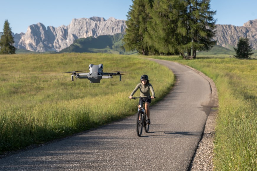Špičkový dron DJI Mini 5 Pro Fly More Combo natáčí ženu na kole