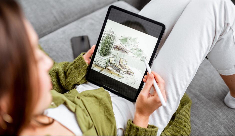 Jak vybrat tablet? žena leží na pohovce a pracuje na grafickém tabletu pomocí stylusu