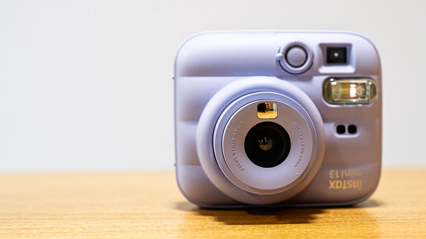 Recenze: Fujifilm instax Mini 13 – Instantní fotoaparát, který promění vzpomínky ve skutečné fotografie pohled na fialový instax Mini 13 zepředu