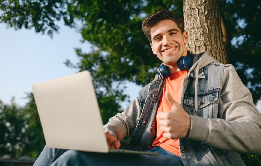 Jak dát notebook do továrního nastavení? Zvládnete to sami bez servisu muž sedí na lavičce s notebookem na klíně