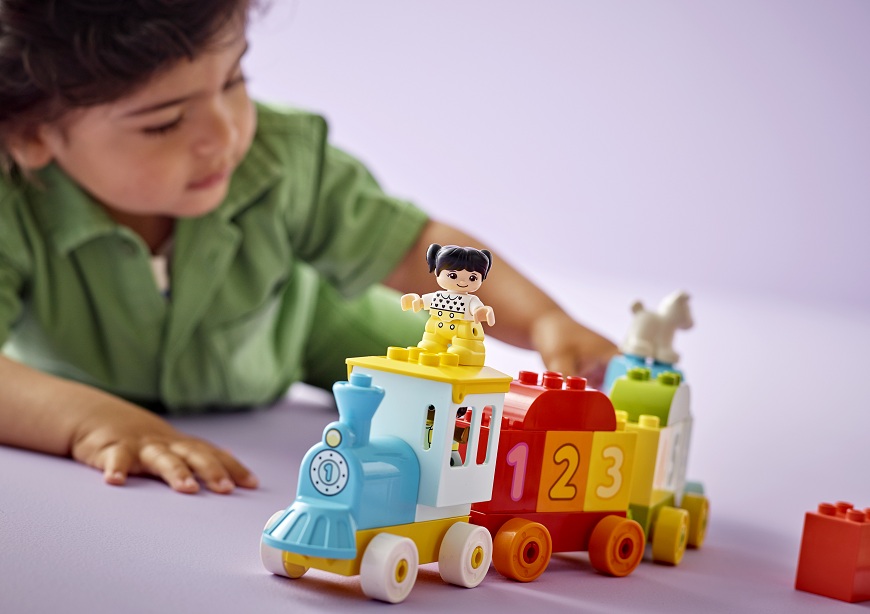 Malý chlapec si hraje s vláčkem LEGO DUPLO.