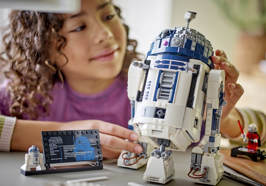 Dívka skládá stavebnici LEGO Star Wars R2 D2.