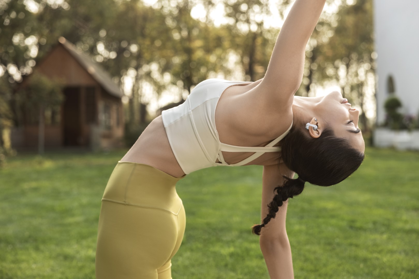 Shokz OpenDots 2 a OpenDots Air: Otevřená sluchátka, která vás neodříznou od okolí Žena cvičí jógu s otevřenými sluchátky Shokz OpenDots 2