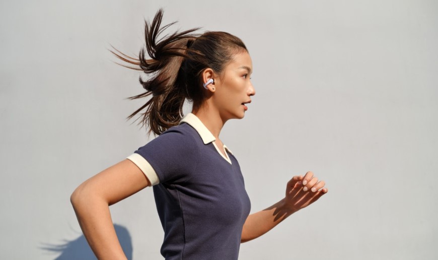 Shokz OpenDots 2 a OpenDots Air: Otevřená sluchátka, která vás neodříznou od okolí Žena běhá s otevřenými sluchátky OpenDots Air