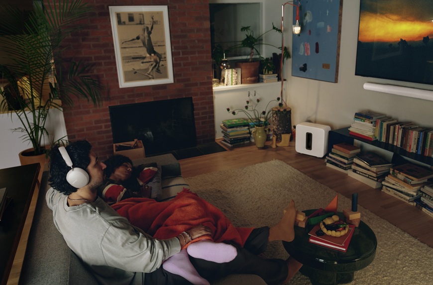 Je až neuvěřitelné, jaký zvuk si můžete užít doma. Sonos uvádí nový soundbar a sluchátka muž v obývacím pokoji se sluchátky Sonos sleduje tv se soundbarem Sonos