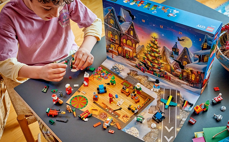 Chlapec si hraje u stolu s adventním kalendářem LEGO® City 60510 Adventní kalendář 2026