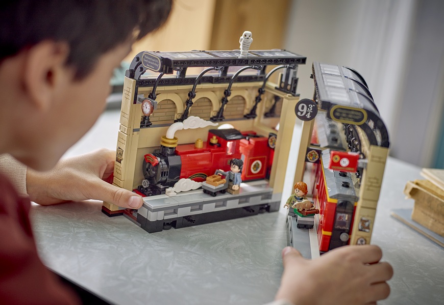 Chlapec si u stolu hraje se stavebnicí LEGO® Harry Potter™ 76450 Knižní zarážka: Spěšný vlak do Bradavic.