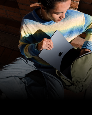 Osoba si do batohu dává 15palcový MacBook&nbsp;Air v&nbsp;temně inkoustové barvě